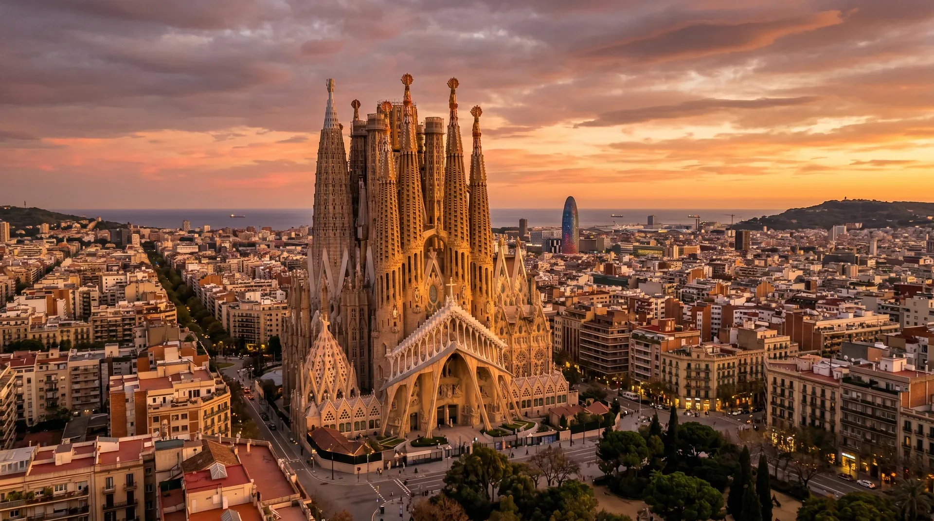 The Sagrada Família at golden hour with Barcelona cityscape behind it